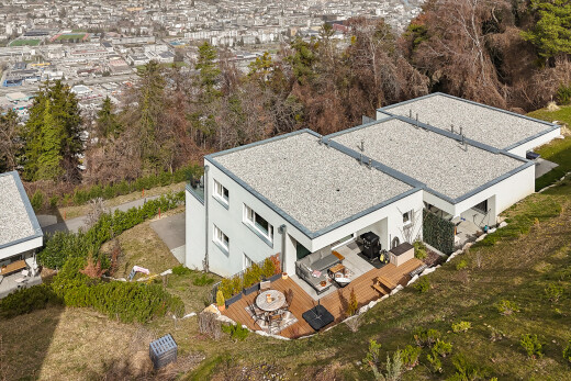 façade avec property visible, bardage en stuc, pelouse, toit en goudron et gravier, et terrasse