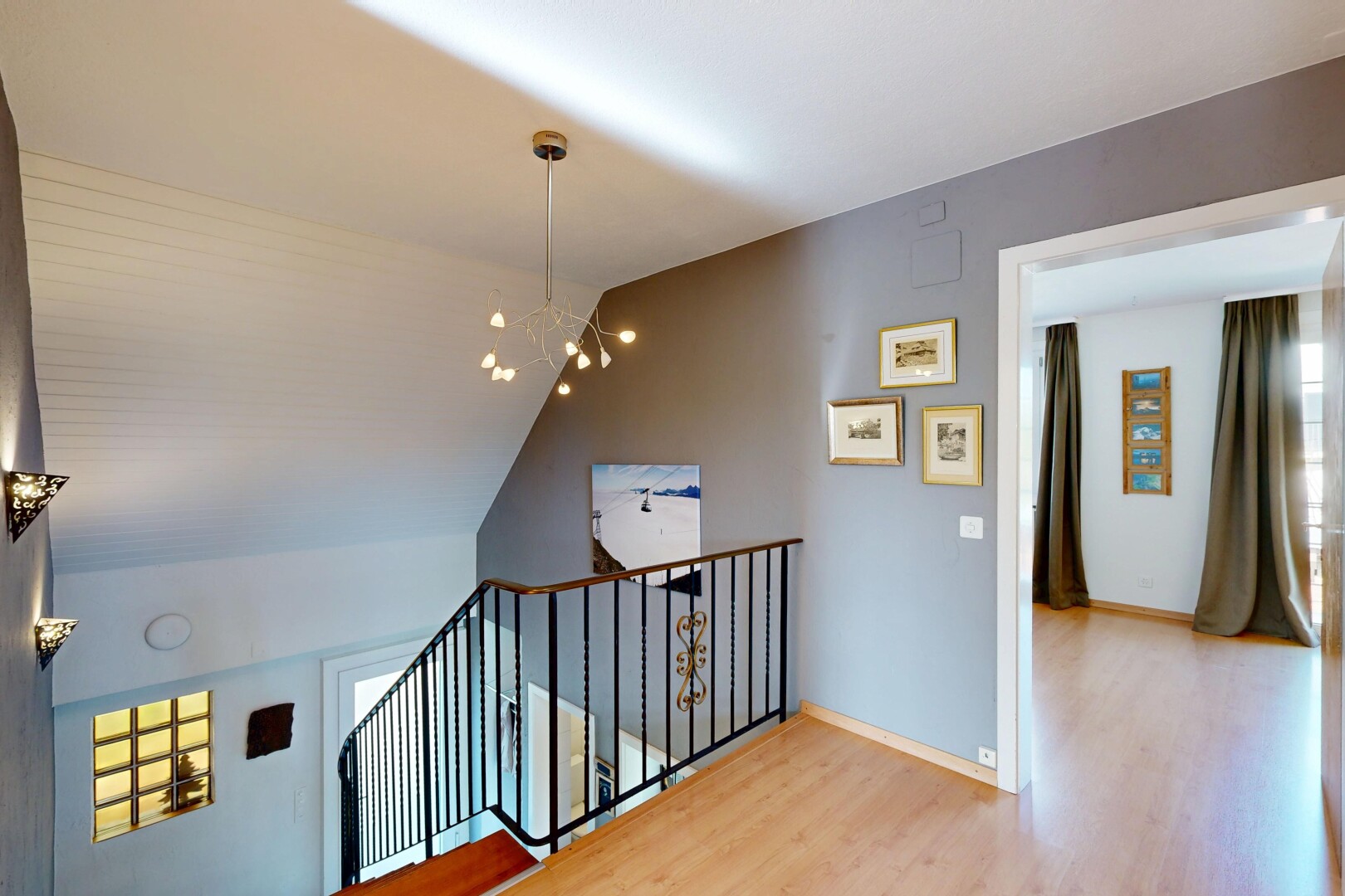 escaliers avec cloison sèche, drywall, inside property, lustre remarquable, et sol en finition bois