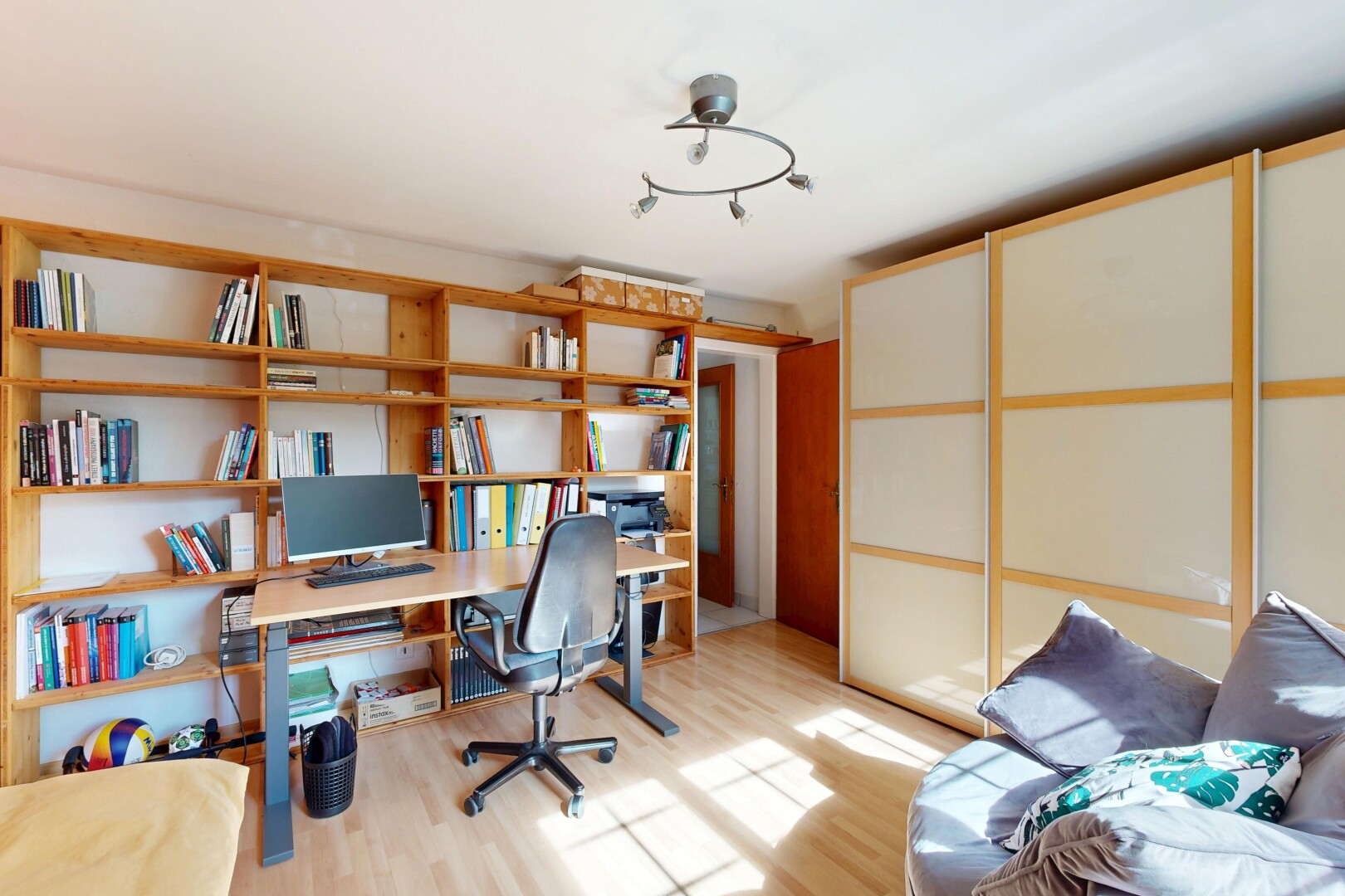 bureau avec sol en finition bois, wood finish floor, inside property, espace bureau, et télévision