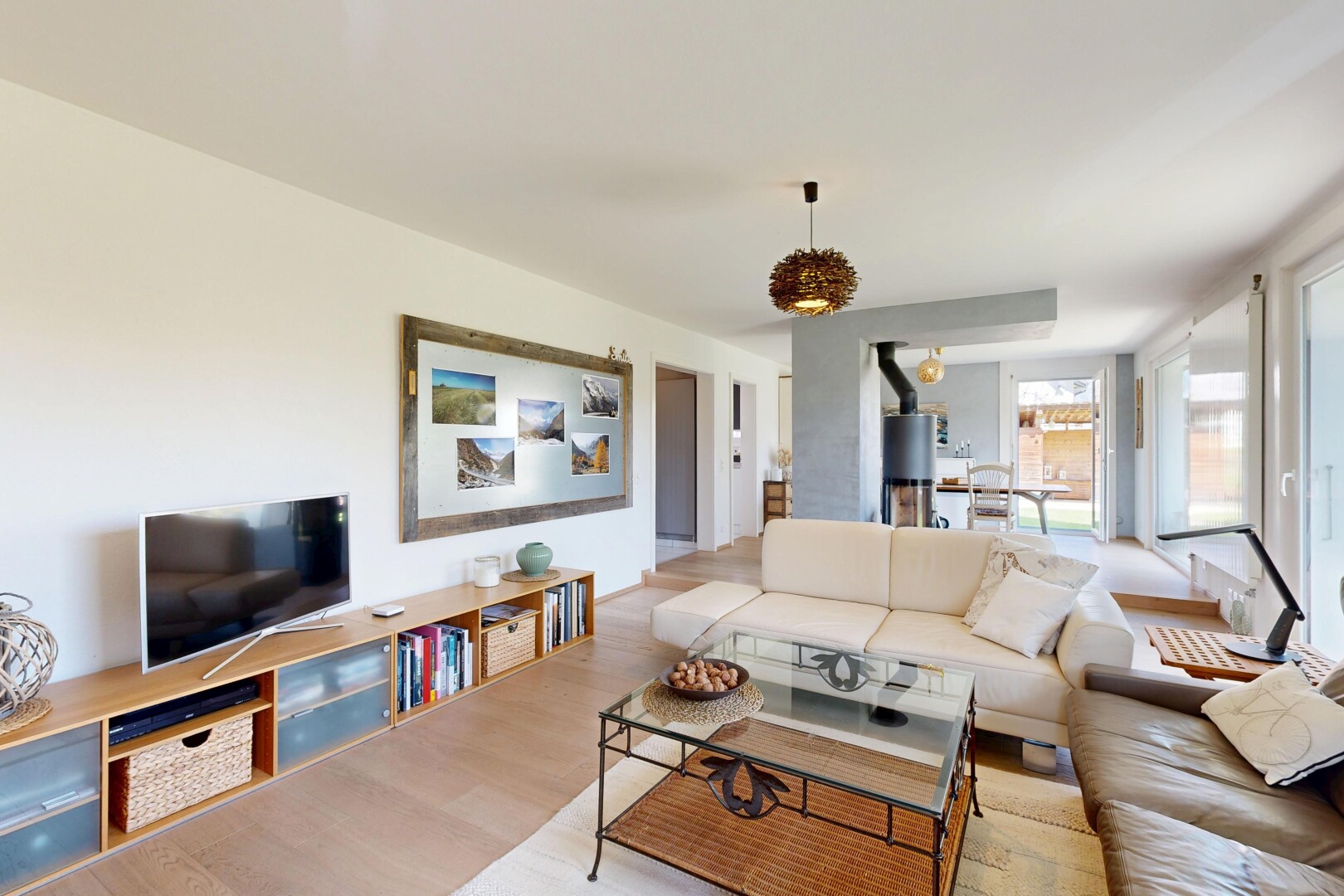 salon avec inside property, télévision, cloison sèche, drywall, et sol en finition bois