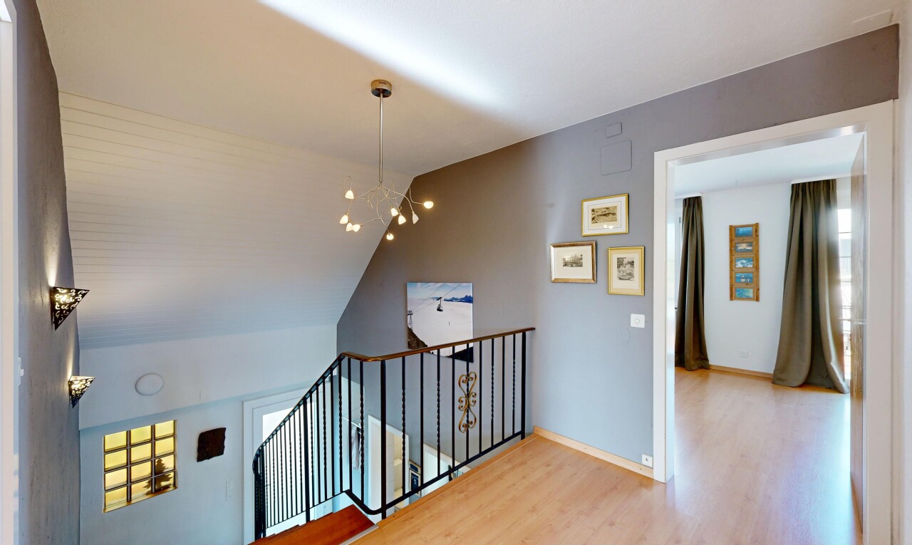escaliers avec cloison sèche, drywall, inside property, lustre remarquable, et sol en finition bois
