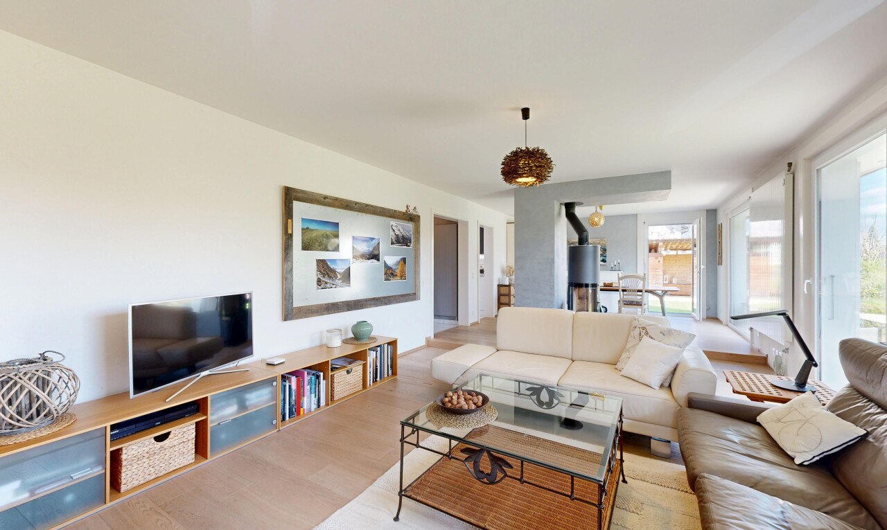 salon avec inside property, télévision, cloison sèche, drywall, et sol en finition bois