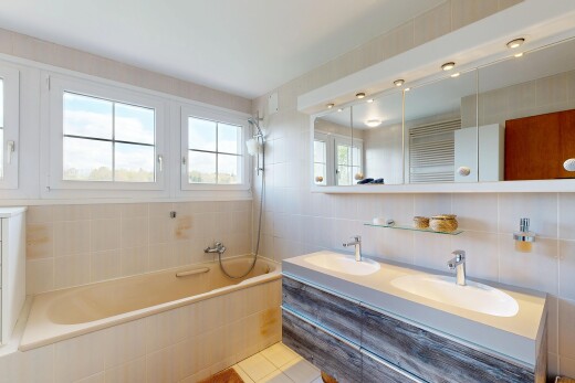 salle de bains avec salle de bain complète, double vasque, mur en carrelage, tile wall, et évier