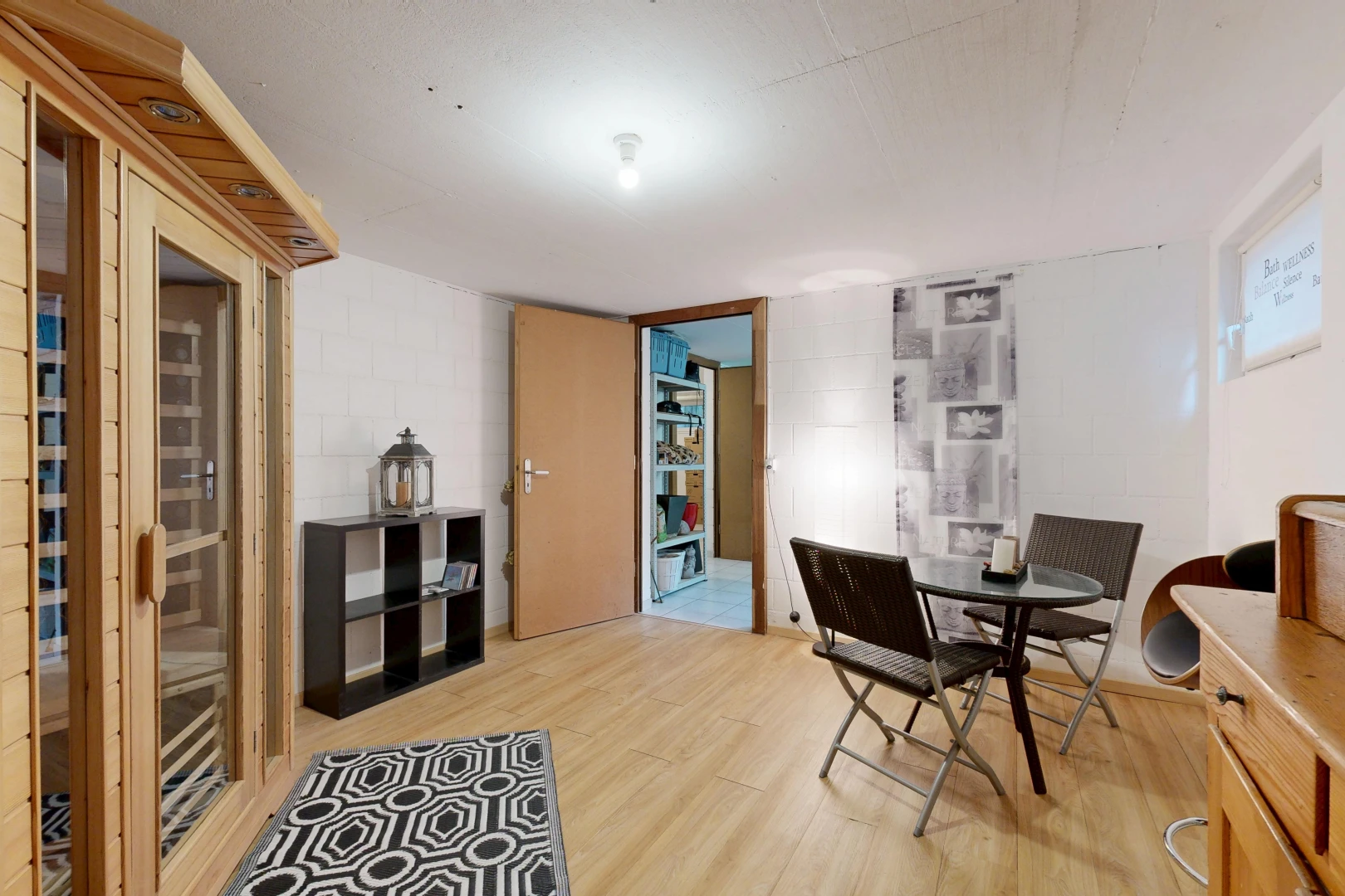 dining area featuring concrete block wall, light wood finished floors, and a relaxing sauna
