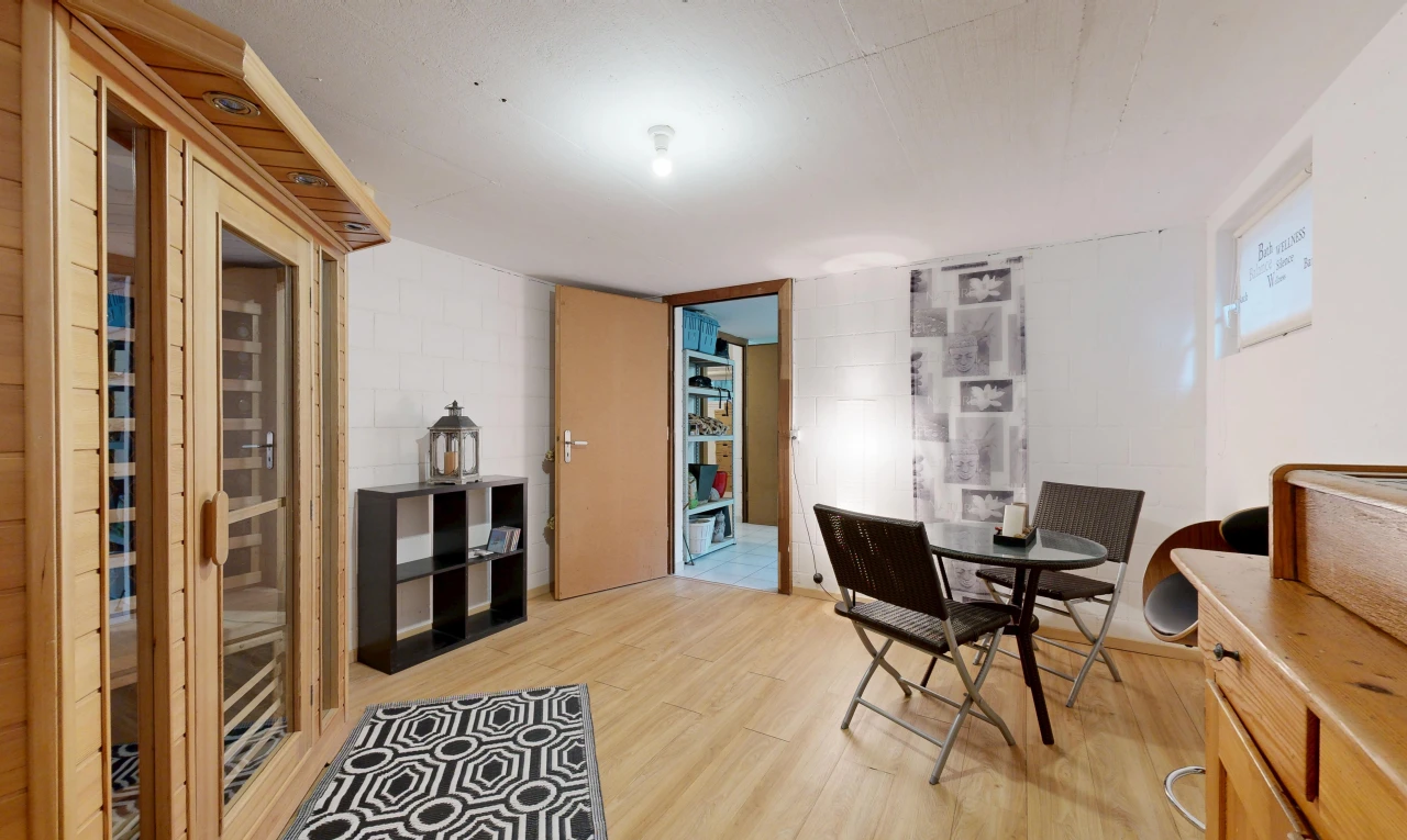 dining area featuring concrete block wall, light wood finished floors, and a relaxing sauna