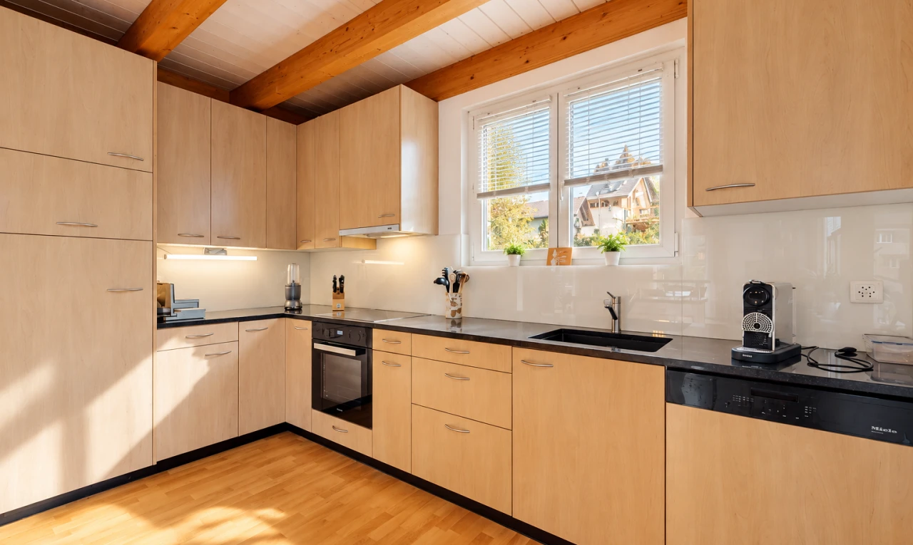 kitchen featuring dark countertops, dishwasher, light wood finish cabinetry, black oven, and light wood-style floors