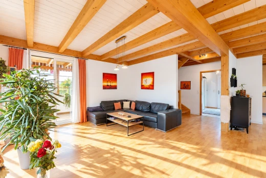living area featuring light wood-type flooring, a wooden ceiling with exposed beams, and access to outside