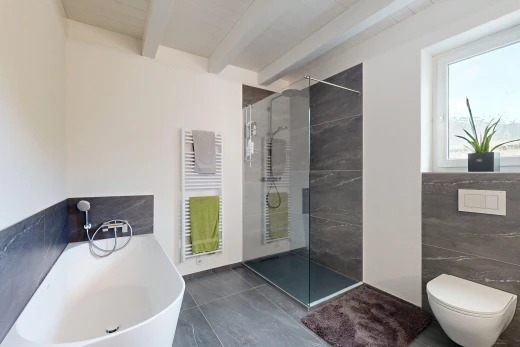 full bathroom featuring a towel warmer, radiator heating unit, a soaking tub, walk in shower, and beam ceiling