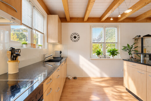 cuisine avec dark countertops, beamed ceiling, plafond à poutres, plaque de cuisson, et évier