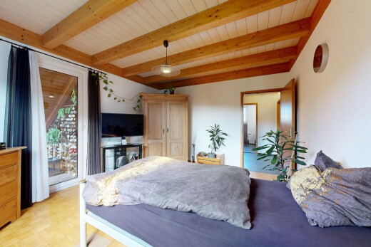 chambre avec drywall, cloison sèche, beamed ceiling, plafond à poutres, et télévision