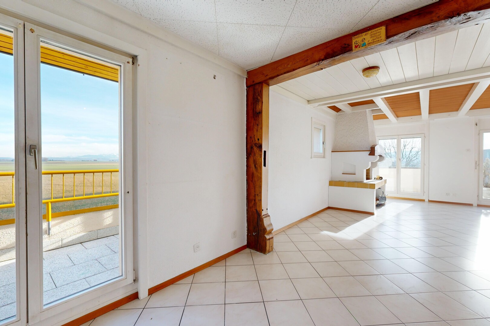 pièce vide avec inside property, natural light, lumière naturelle, beamed ceiling, et plafond à poutres