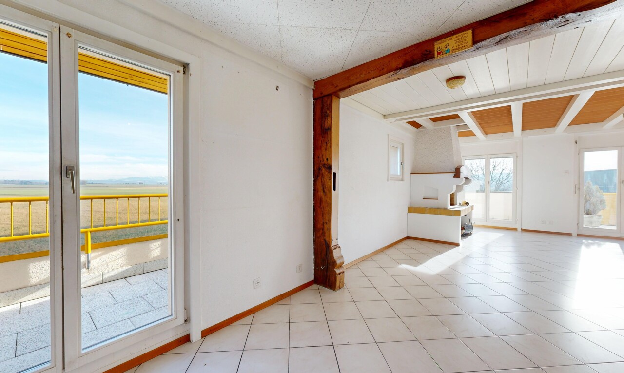 pièce vide avec inside property, natural light, lumière naturelle, beamed ceiling, et plafond à poutres
