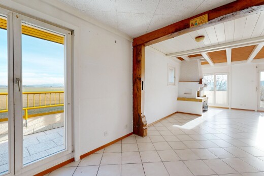 pièce vide avec inside property, natural light, lumière naturelle, beamed ceiling, et plafond à poutres