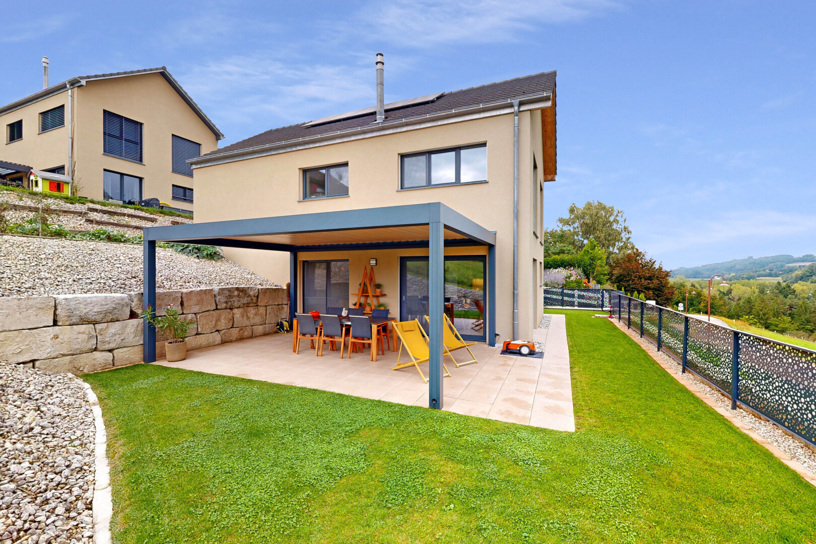 outdoor house with a patio, stucco siding, a fenced backyard, and solar panels