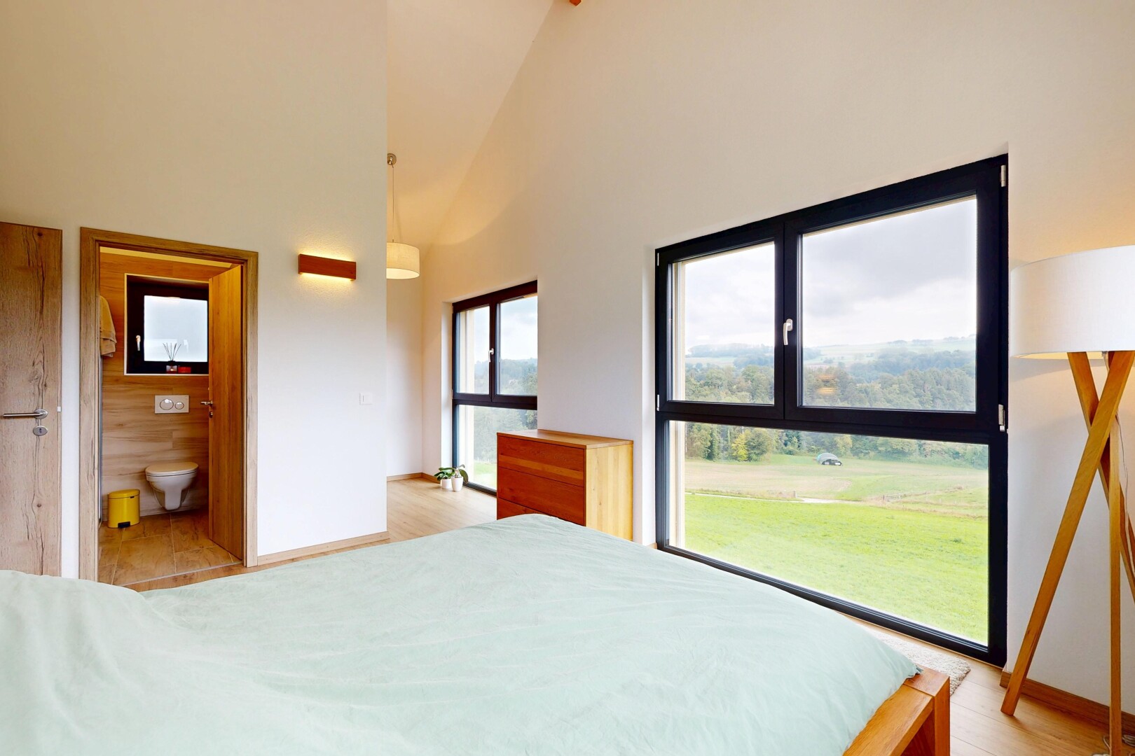 room with high vaulted ceiling, light wood finished floors, and connected bathroom