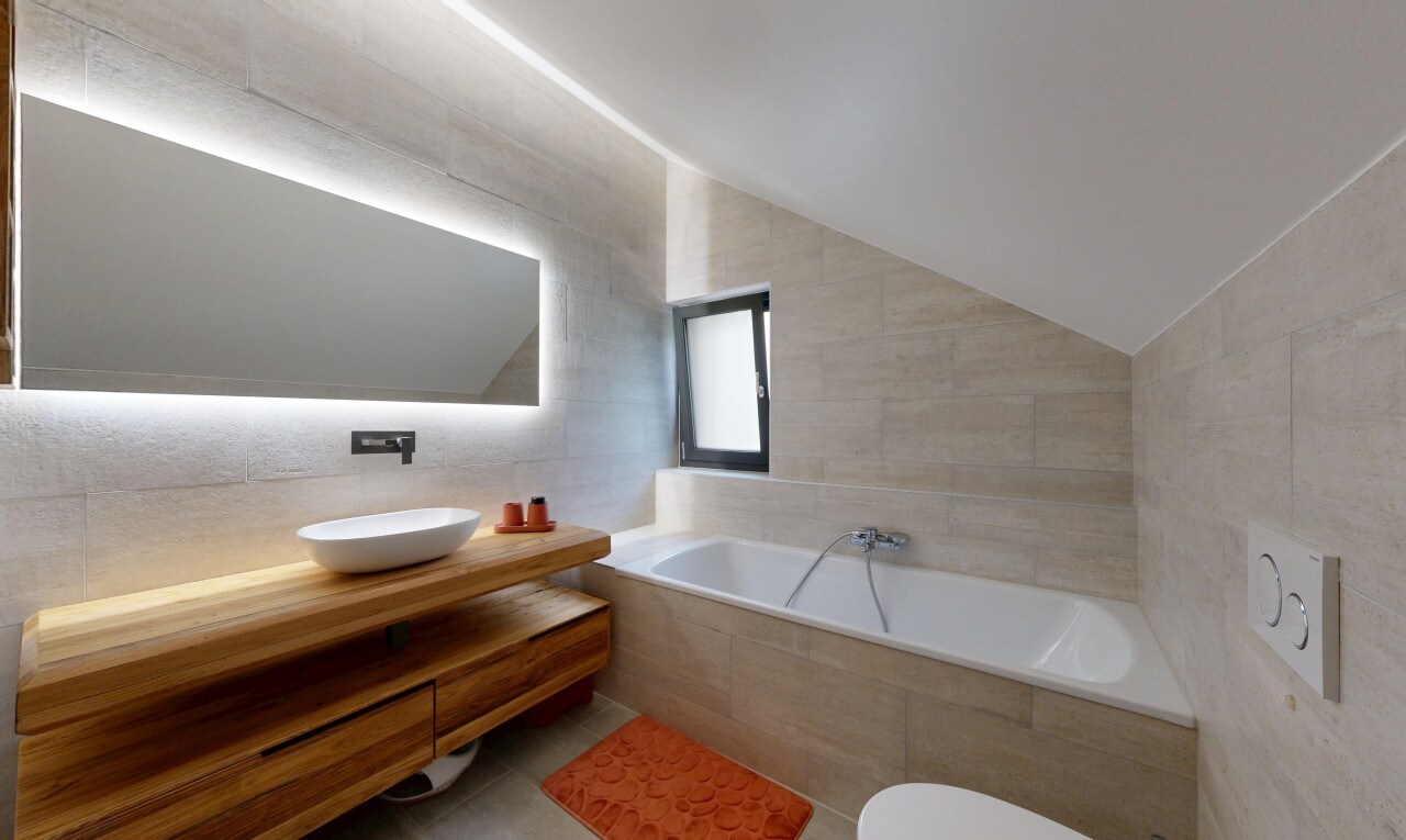 bathroom featuring tile walls, a bath, vanity, and vaulted ceiling