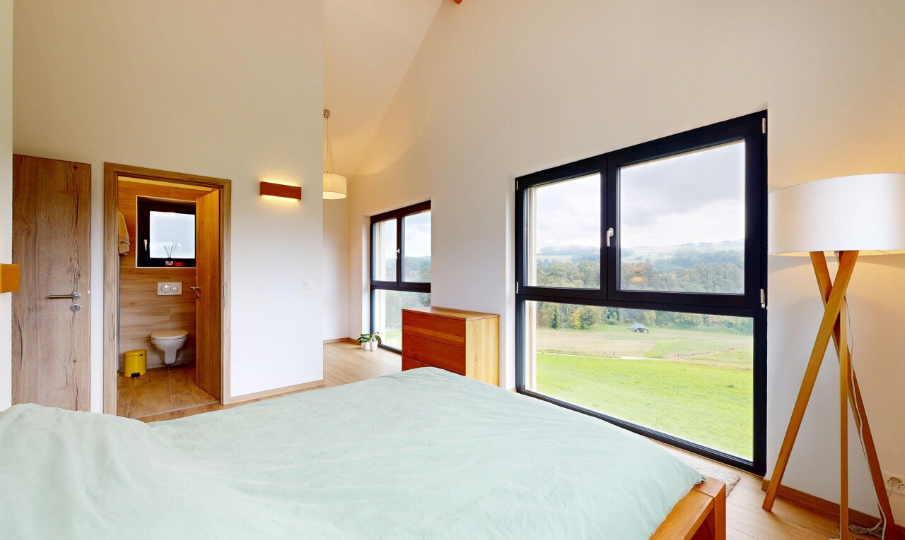 room with high vaulted ceiling, light wood finished floors, and connected bathroom
