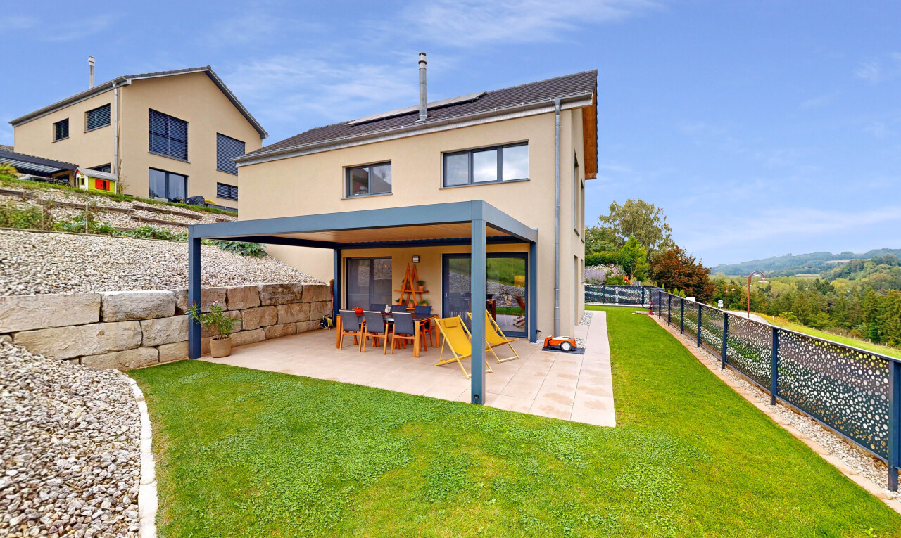 outdoor house with a patio, stucco siding, a fenced backyard, and solar panels