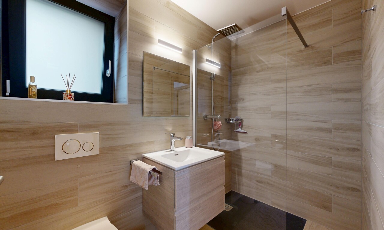 full bathroom with vanity, a walk in shower, and tile walls