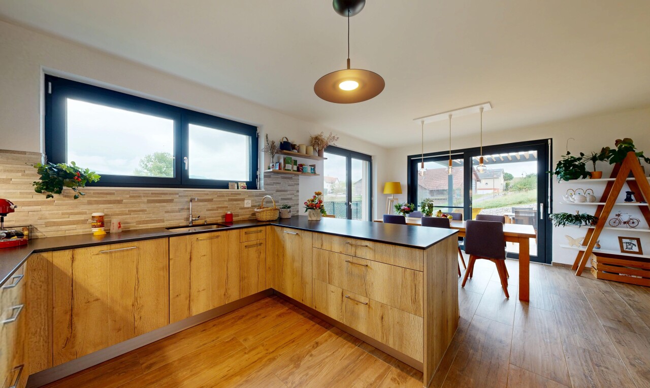 kitchen with a peninsula, hanging light fixtures, modern cabinets, light wood-style flooring, and dark countertops