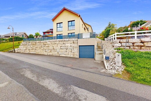 façade avec bardage en stuc, day time, property visible, garage intégré, et clôture