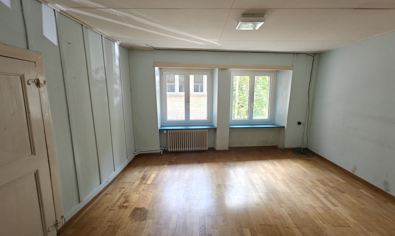 pièce vide avec natural light, lumière naturelle, radiateur, wood finish floor, et sol en finition bois