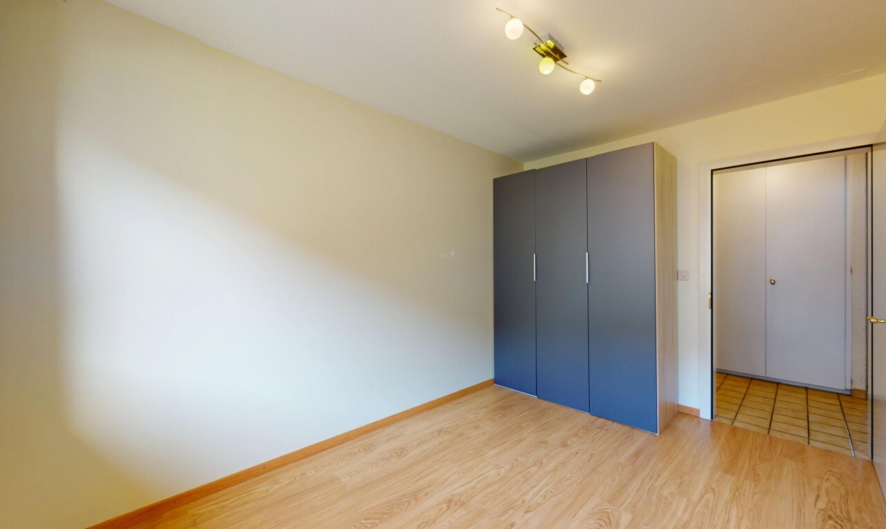 chambre avec plinthes murales, sol en finition bois, et cloison sèche