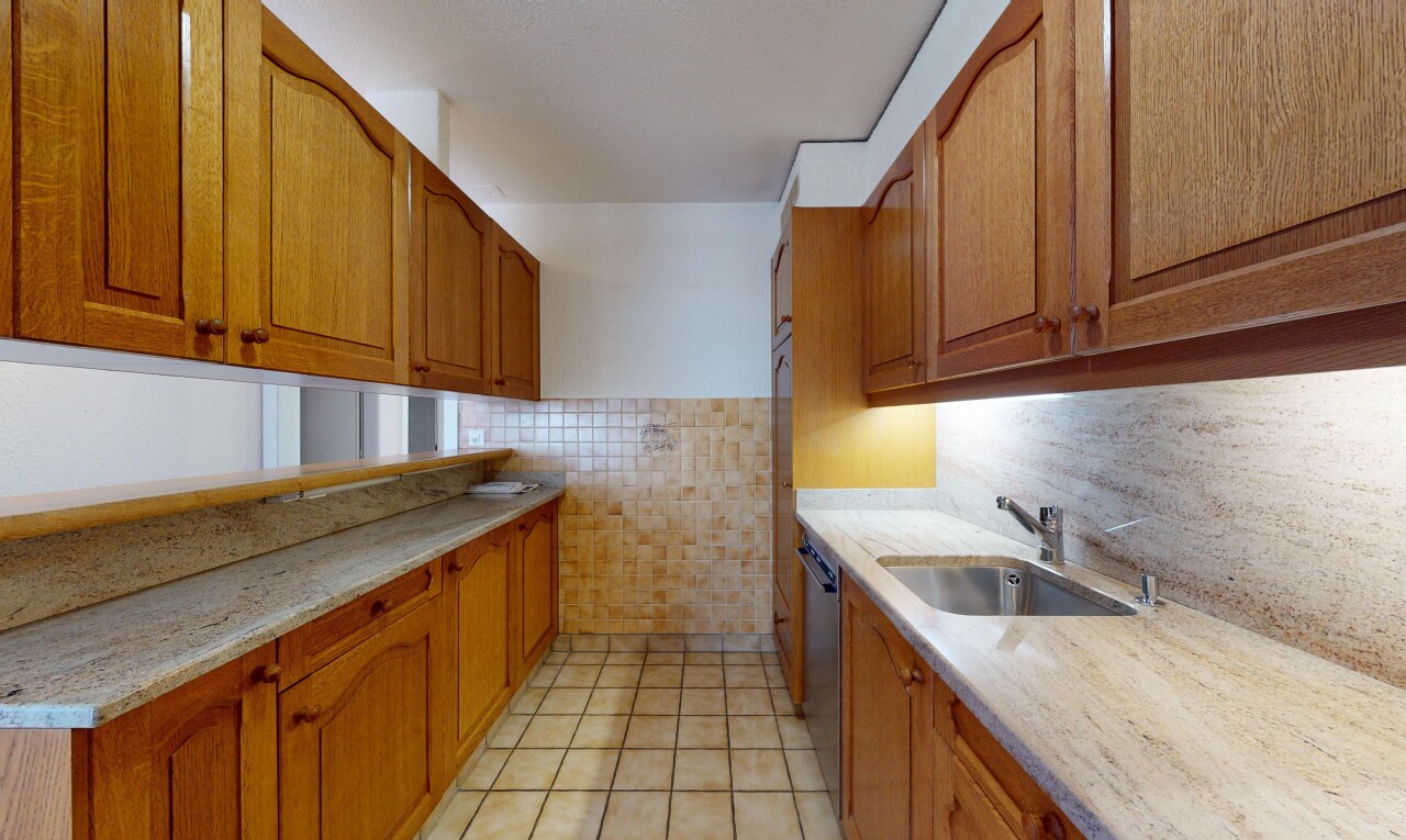 cuisine avec armoires marron moyen, lave-vaisselle, mur en carrelage, et évier