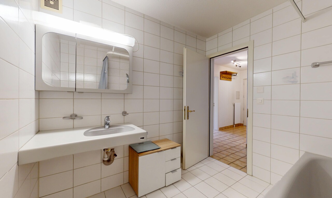 salle de bains avec sol en carrelage, ventilation, mur en carrelage, et miroir