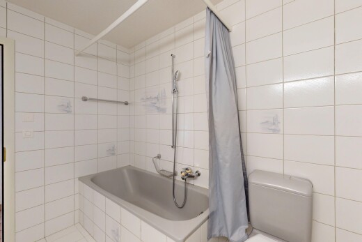 salle de bains avec salle de bain complète, toilette, mur en carrelage, et douche-bain combinés