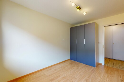 chambre avec plinthes murales, sol en finition bois, et cloison sèche