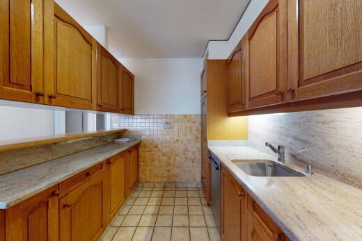 cuisine avec armoires marron moyen, lave-vaisselle, mur en carrelage, et évier