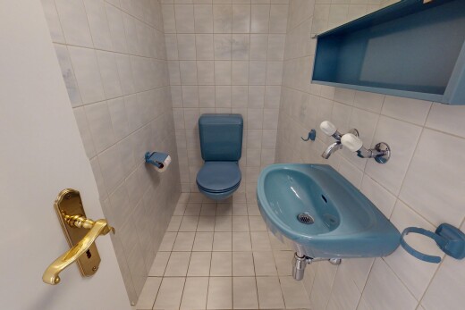 salle de bains avec évier, mur en carrelage, et toilette