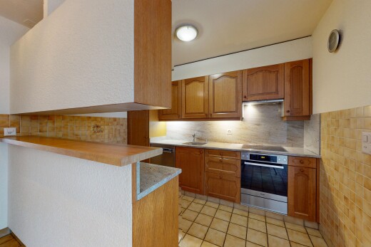 cuisine avec armoires marron moyen, four, plaque de cuisson, plans de travail, et armoires en arc