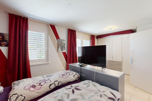 zimmer / schlafzimmer mit fliesenboden, natürliches licht, und fernseher