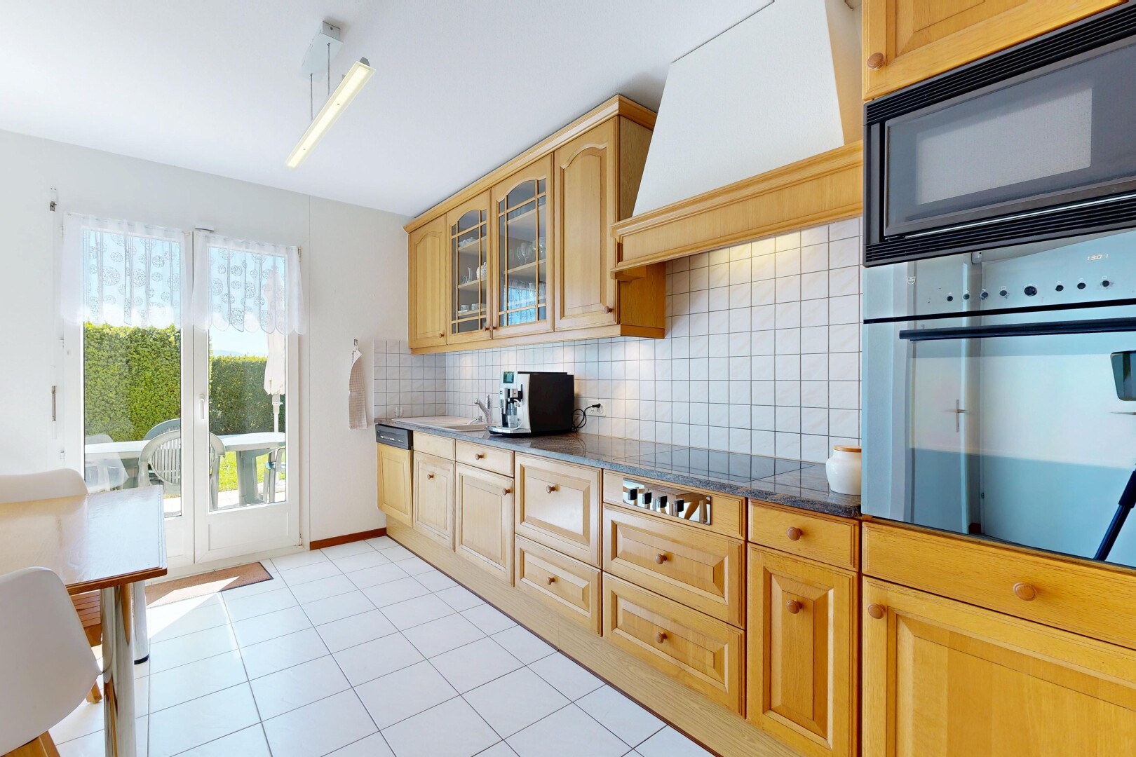 küche mit bogenförmige schränke, arched cabinets, mikrowelle, dark countertops, und ofen