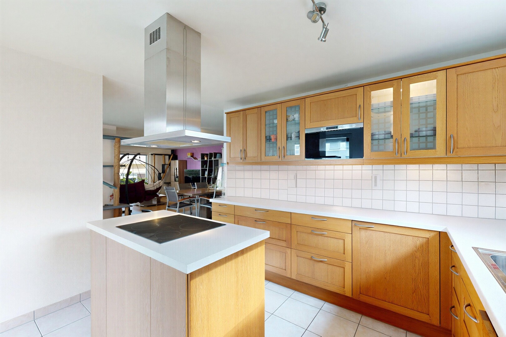 cuisine avec light countertops, plans de travail, light floor, hotte, et backsplash