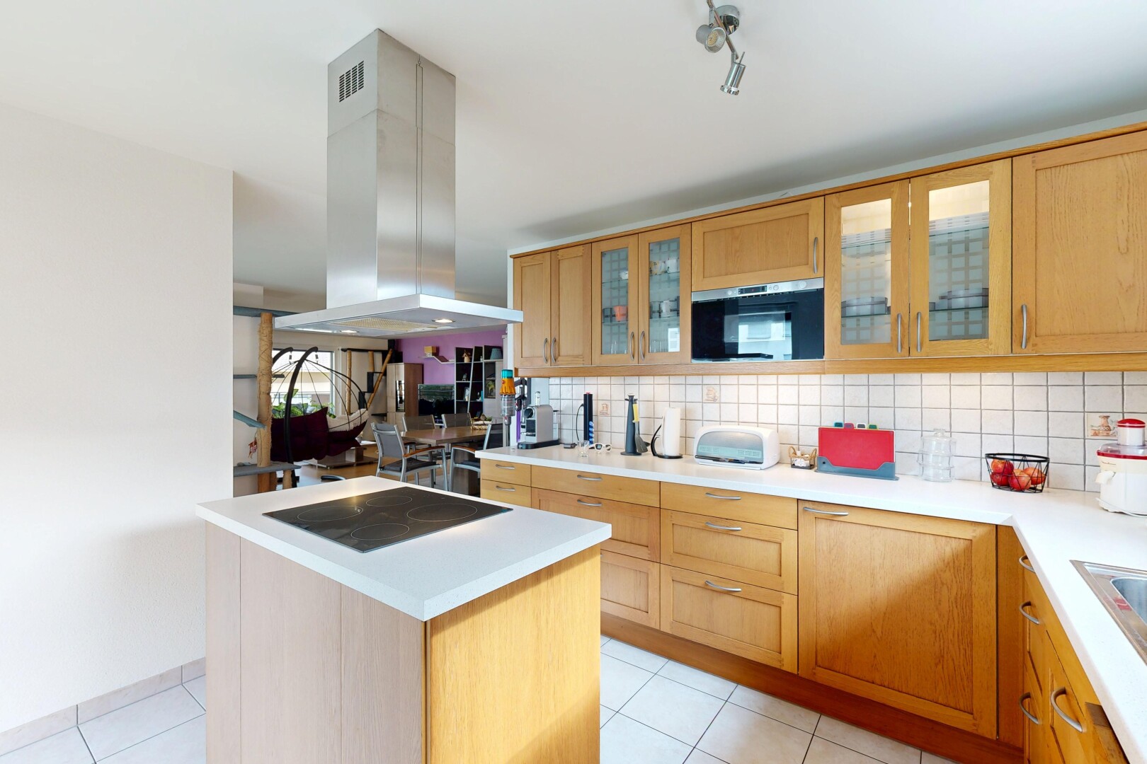 cuisine avec light countertops, plans de travail, light floor, hotte, et backsplash