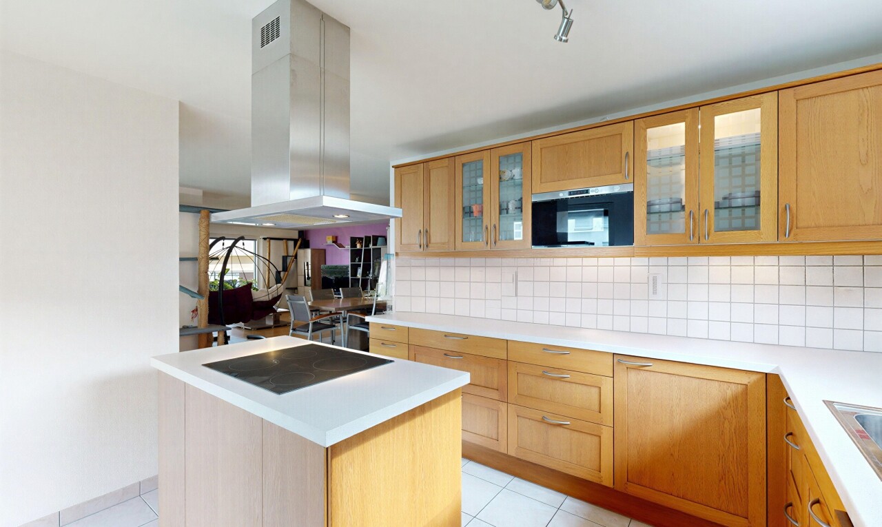 cuisine avec light countertops, plans de travail, light floor, hotte, et backsplash