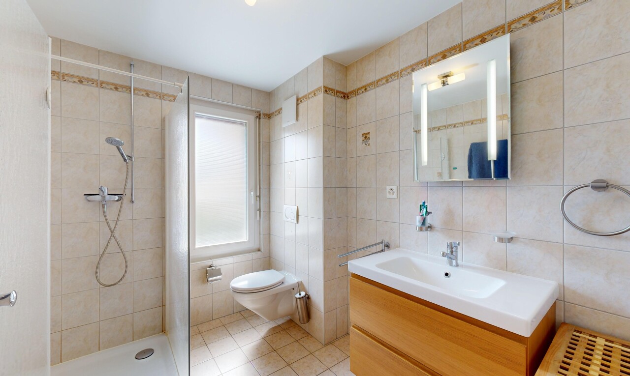 salle de bains avec tile wall, mur en carrelage, lavabo (ou coiffeuse selon le contexte), salle de bain complète, et douche
