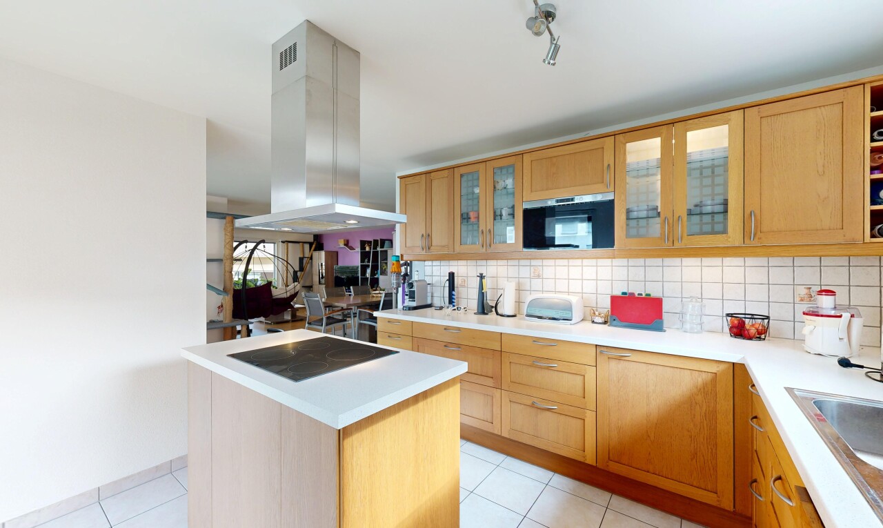 cuisine avec light countertops, plans de travail, light floor, hotte, et backsplash