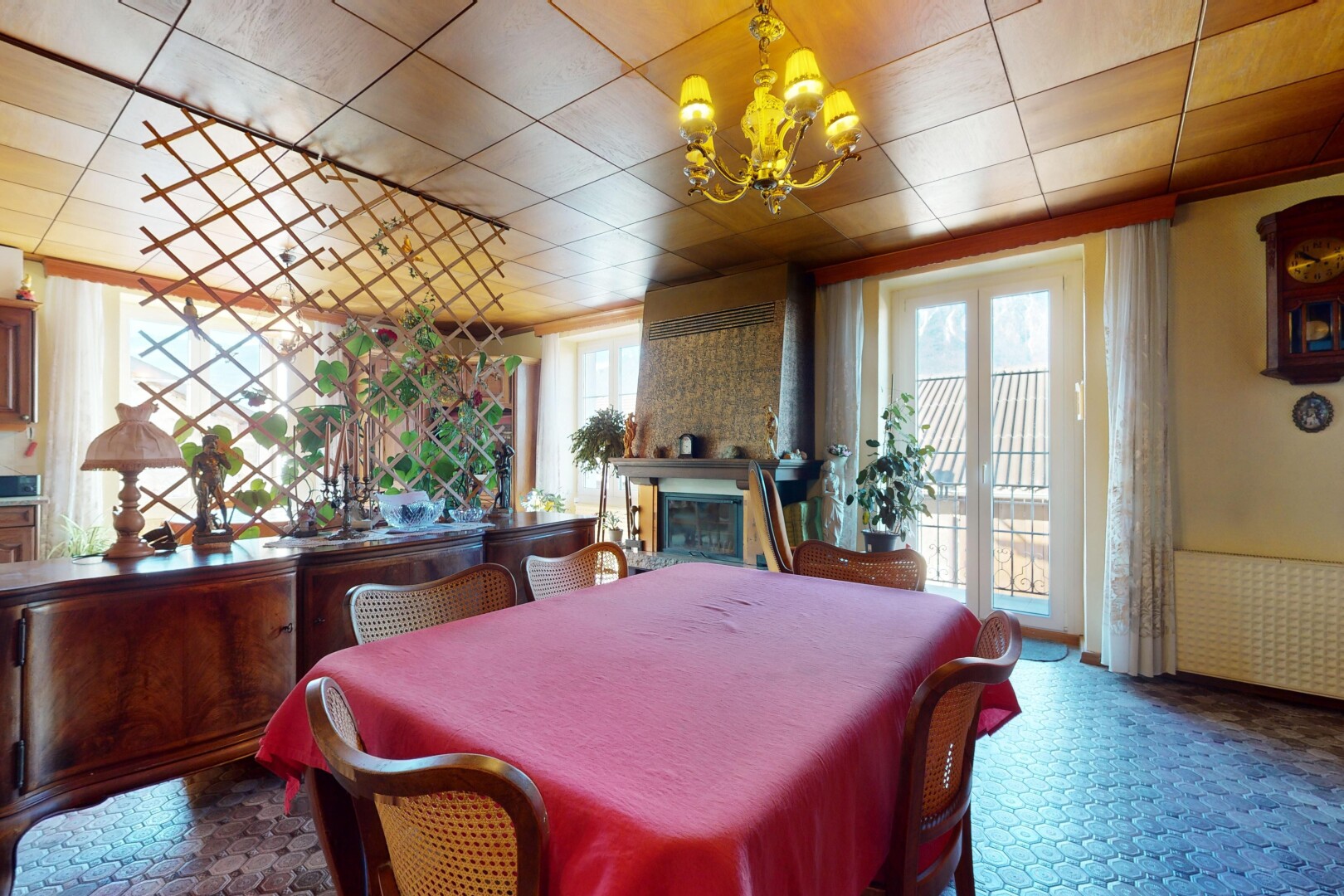 salle à manger avec cheminée, lumière naturelle, et lustre