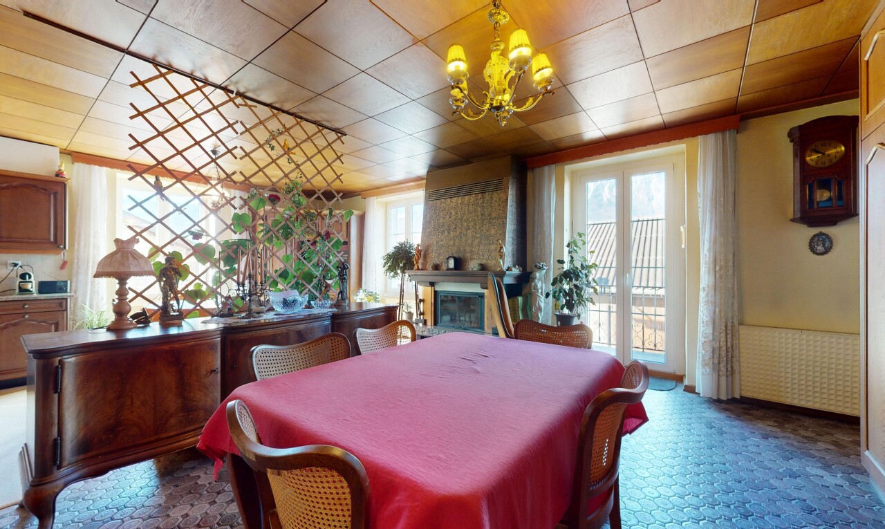 salle à manger avec cheminée, lumière naturelle, et lustre