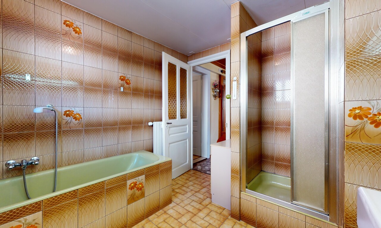salle de bains avec douche, mur carrelé, et baignoire
