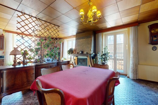 salle à manger avec cheminée, lumière naturelle, et lustre