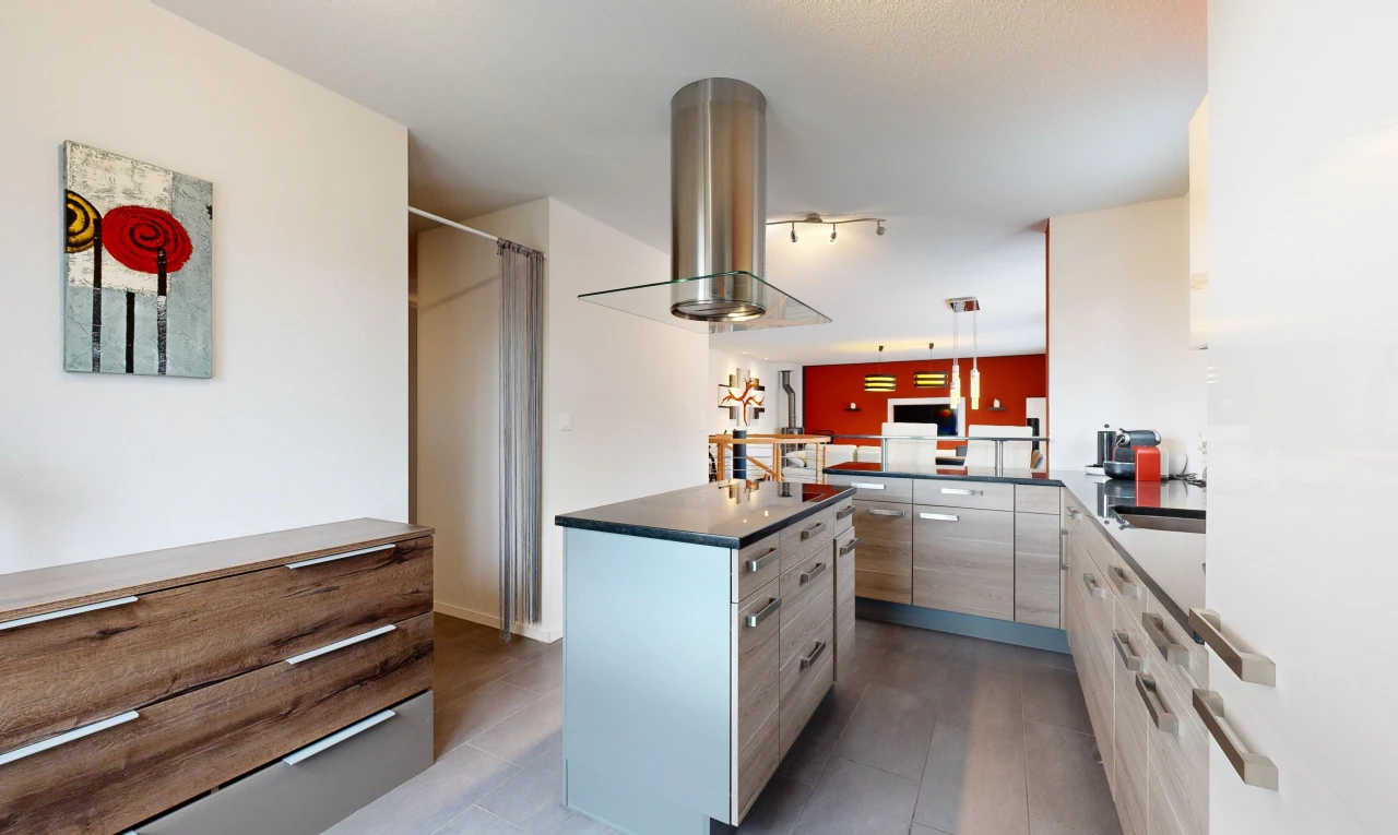 kitchen featuring decorative light fixtures, a kitchen island, sink, and island exhaust hood