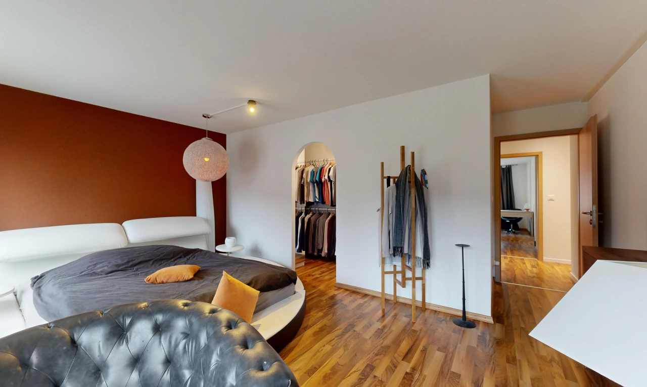 room / bedroom with a closet, a spacious closet, and dark hardwood / wood-style flooring