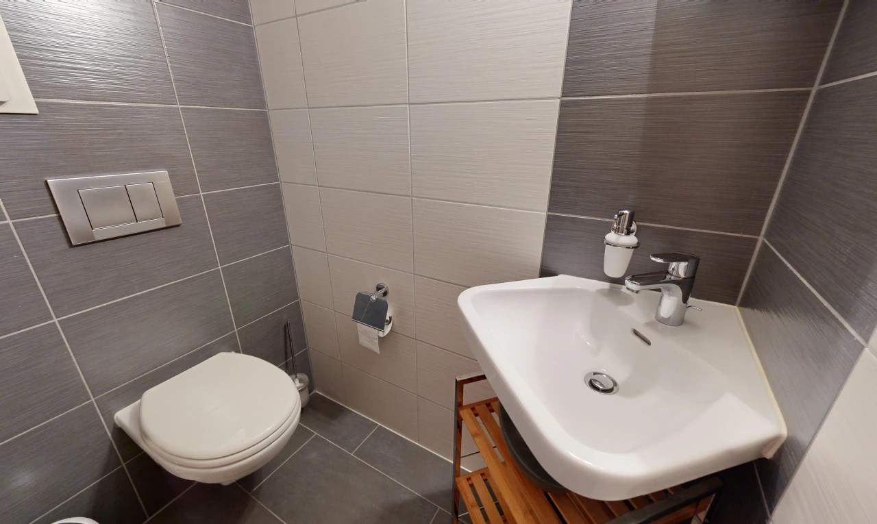 bathroom featuring tile patterned floors, vanity, toilet, and tile walls