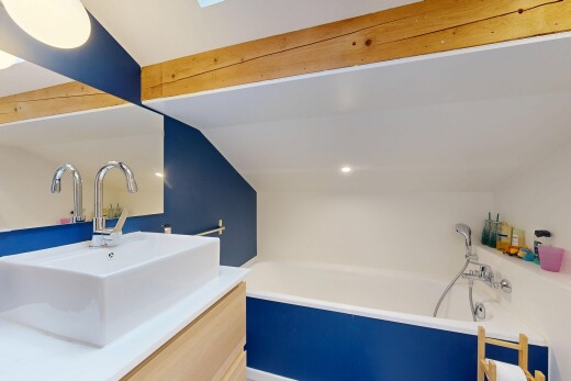 salle de bains avec salle de bain complète, bain, évier, plafond voûté, et lavabo (ou coiffeuse selon le contexte)