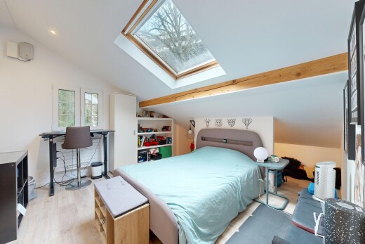 chambre avec plafond voûté, puits de lumière, pièce supplémentaire, et sol en finition bois